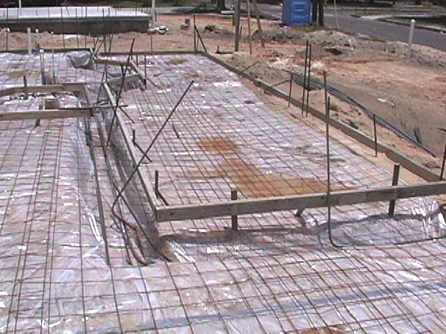 Footings, stem walls, utilities, fill, and slabs for the two Rinoldo houses.