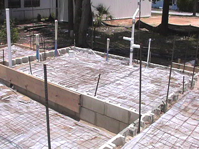 Footings, stem walls, utilities, fill, and slabs for the two Rinoldo houses.